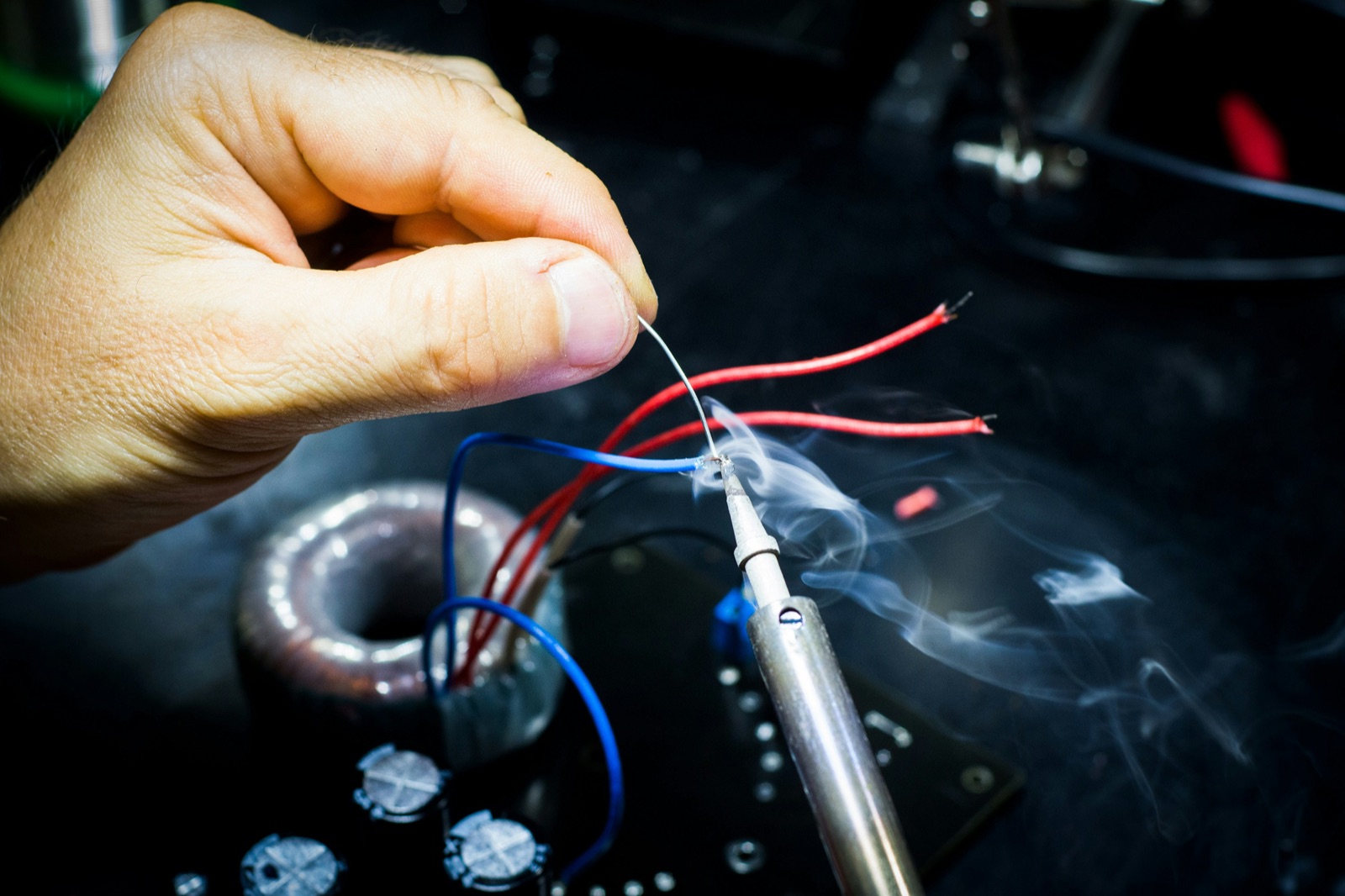 Man soldering wires in electronics workshop for Epo-Weld™ HTP high temperature potting compound electronic potting