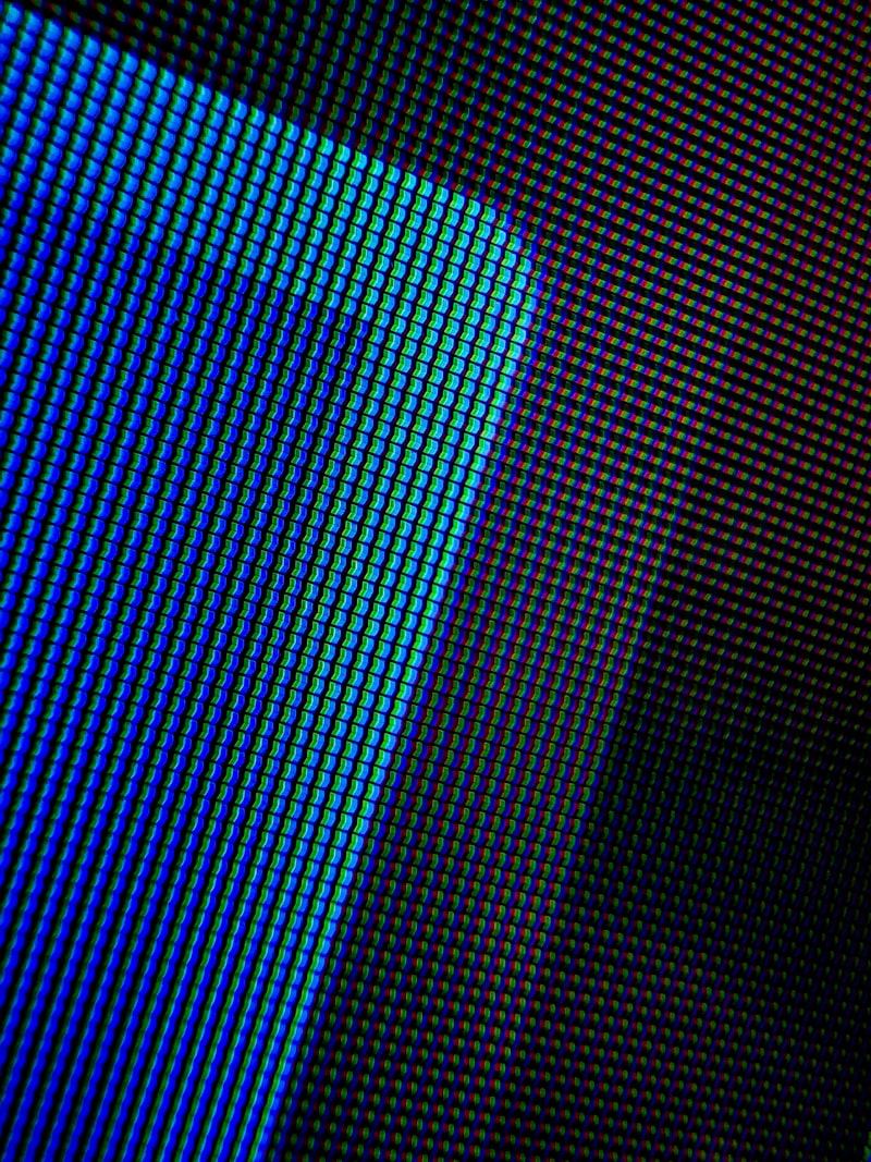 Macro close-up of LED display pixel matrix with blue and teal hues for Optik™ UV display lamination and sensor assembly
